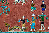 Wat Xieng Thong temple in Luang Prabang, Laos.  La Chapelle Rouge , the Red Chapel. The exterior walls are decorated with colourful mosaics on a pink background with scenes of people daily activities. West wall. 